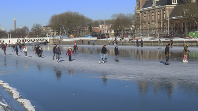 901376 Gezicht op het dichtgevroren Merwedekanaal bij de Muntkade te Utrecht, vanaf de Kanaalweg. Op het kanaal wordt ...